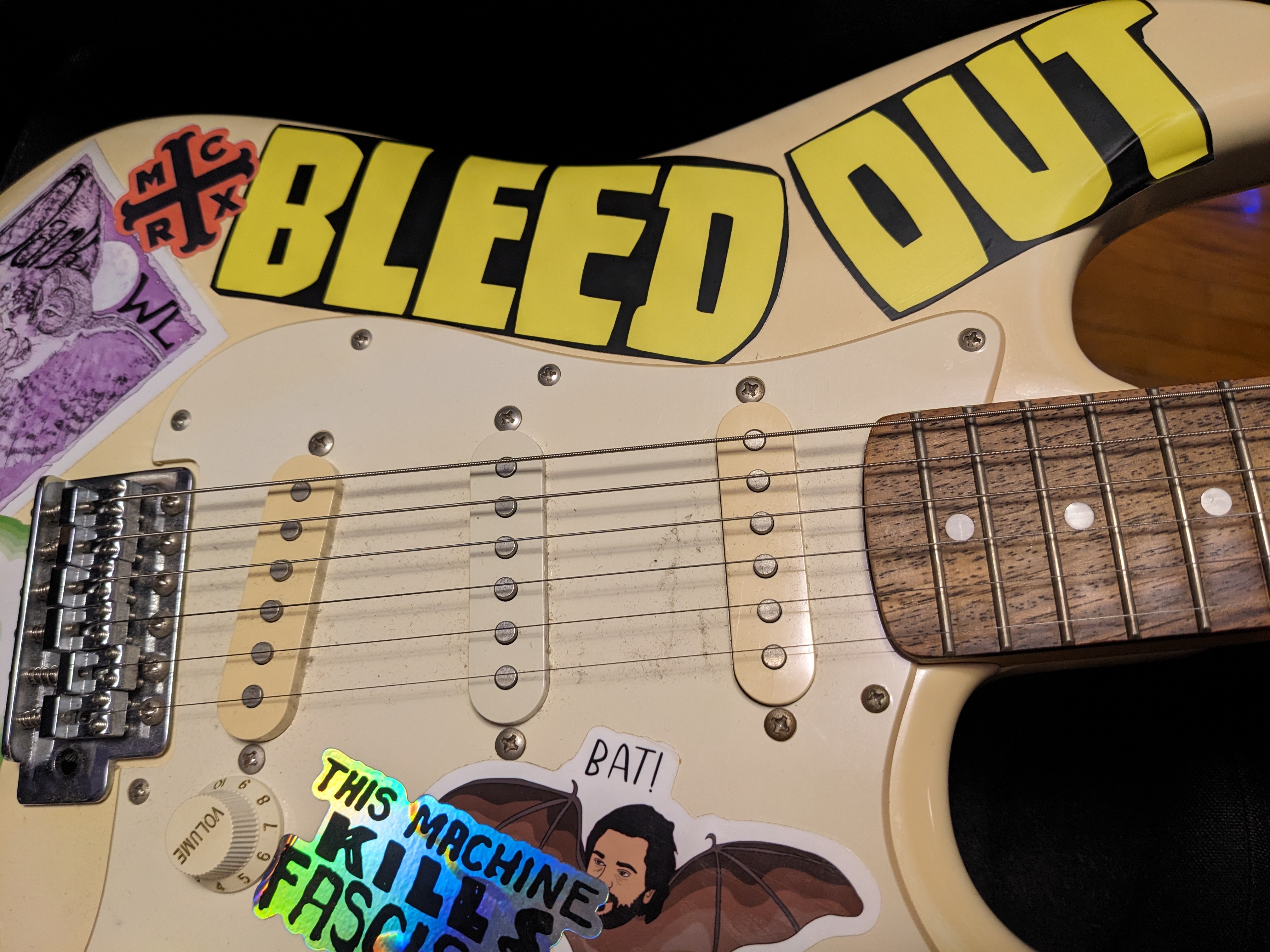 photo of an electric guitar with stickers on it